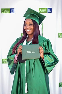 An Excel Center graduate poses with her diploma