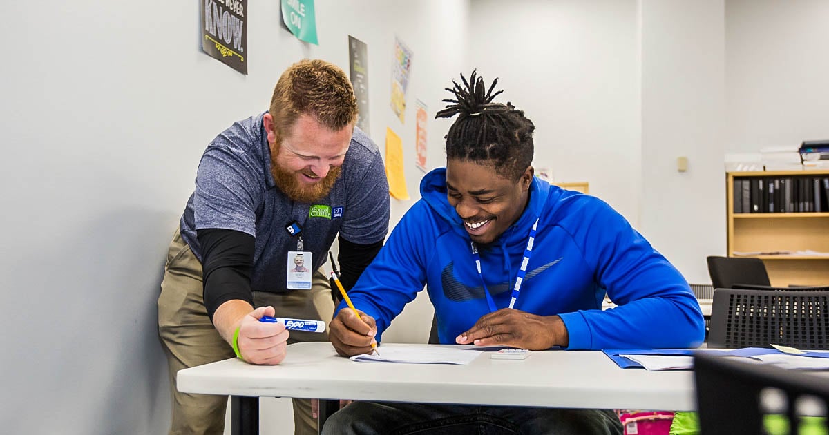 An educator at the Excel Center Laughs with a student.