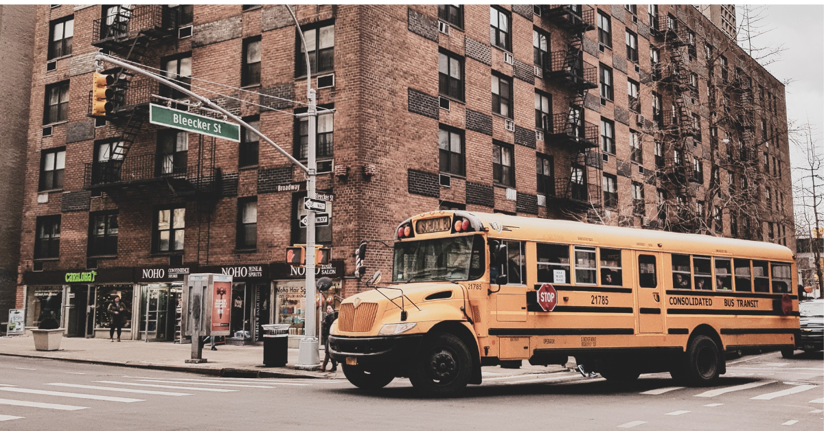 Photo by Yan Berthemy on Unsplash. School bus making its way through traffic.