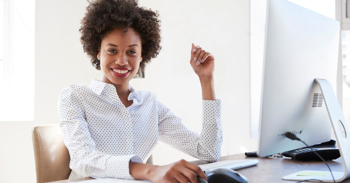 Professional Black woman sitting behind desk smiling