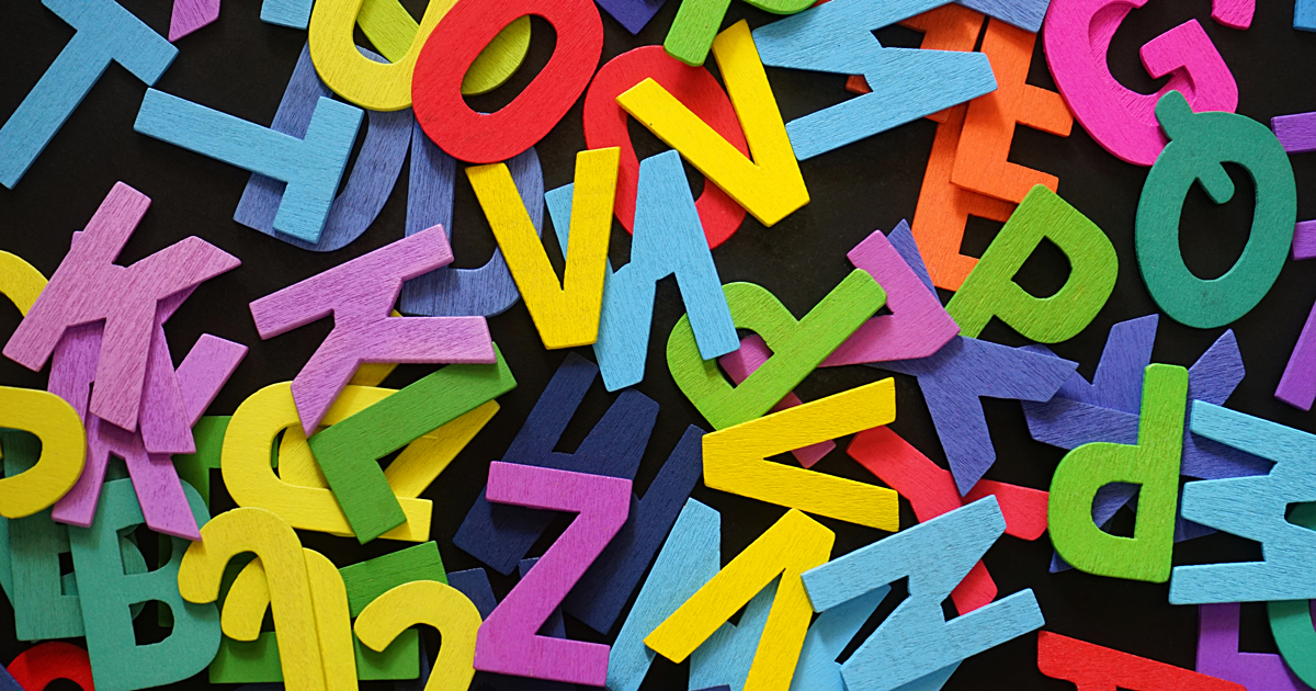 Colorful wooden English alphabet on black background.